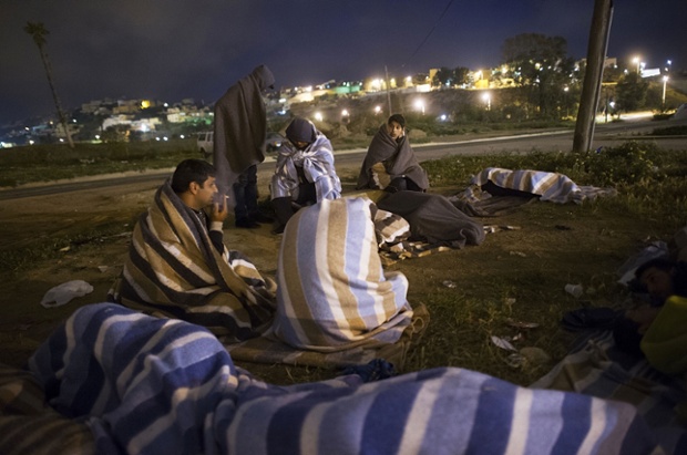 Người tị nạn Syria ngồi bên ngoài Trung tâm tị nạn tạm thời cho những người nhập cư ở Melilla, Tây Ban Nha.