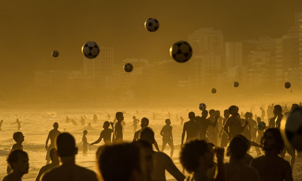 Mọi người chơi bóng đá dưới nắng hoàng hôn trên bãi biển Ipanema Beach ở Rio de Janeiro, Brazil.