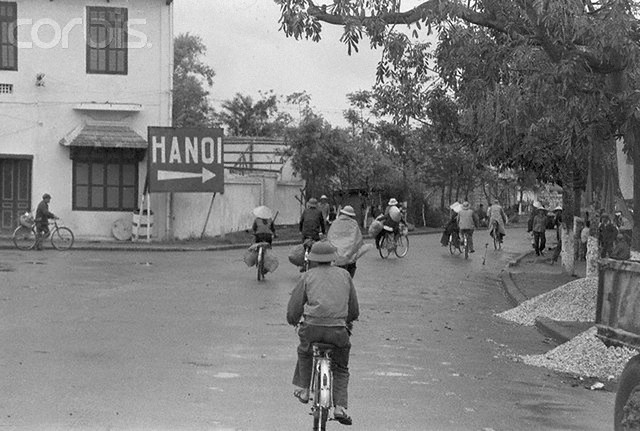 23 Mar 1973, Hanoi, North Vietnam --- Hanoi. Hanoi is to the right. Thats a travel direction only. cyclist move towards North Vietnams big city on the road from the airport recently. UPI city onto he road from the airport recently. UPI correspondent Tracy Wood, who visited Hanoi recently with a group of journalists, reports that bicycles, the main form of transportation for Hanois 1.2 million people, are seen everywhere even though they cost 300 doing, or about $75. One dong is worth about 25cents. One North Vietnamese official said an average worker makes about 50 dong ($12.50) a month. This, and other pictures in the series, were made by UPI staff photographer Gary Bartlett. --- Image by © Bettmann/CORBIS