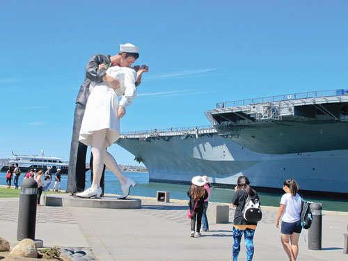  	Du khách trước tượng lưu niệm hải quân đồ sộ bên cạnh tàu bảo tàng Midway.