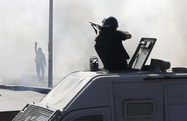 Cảnh sát chống bạo động bắn đạn cao su về phía người biểu tình trước đại học Cairo, Ai Cập.