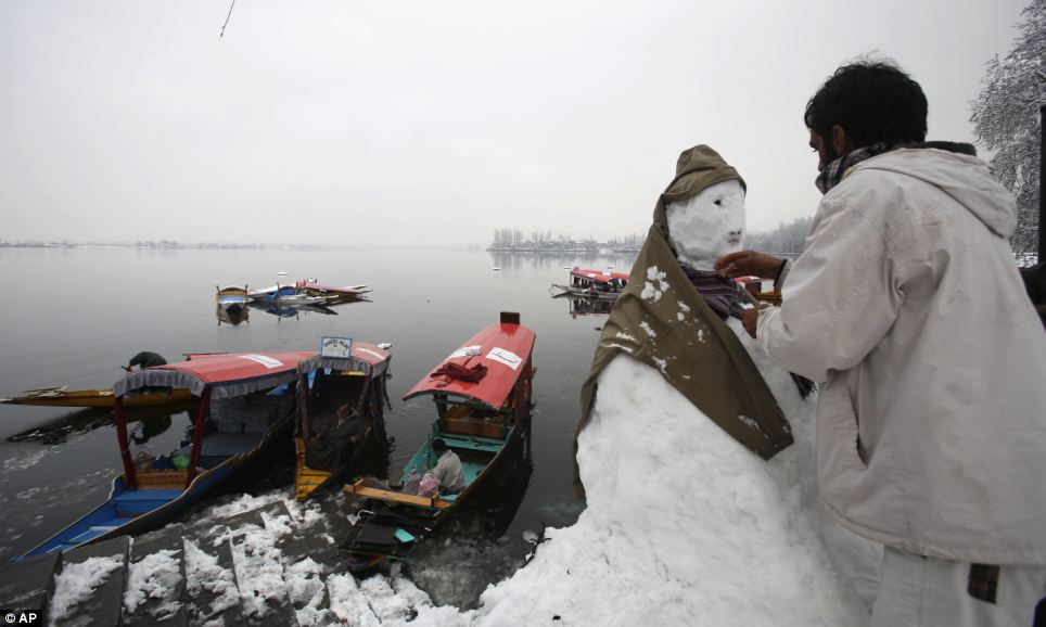 Một lái thuyền Kashmiri làm cho người tuyết ở Lake Dal ở Srinagar.  Hồ cũng là một điểm thu hút du lịch nổi tiếng