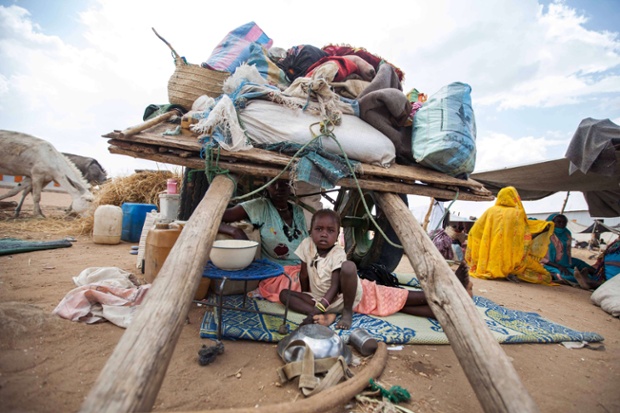 Một đứa trẻ người Sudan ngồi dưới lều tạm tại trại tị nạn dành cho người mất nhà cửa ở Nam Darfur.