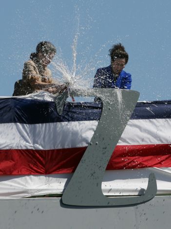 Hai chị em Ann Zumwalt (trái) và Mouzetta Zumwalt (phải) thực hiện nghi lễ đập chai sâm-panh vào biểu tượng chữ Z trên con tàu