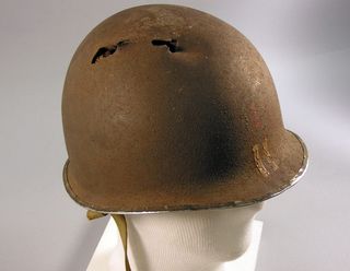 Một chiếc mũ sắt M1 bị bắn xuyên bởi đạn AK trong chiến tranh Việt Nam