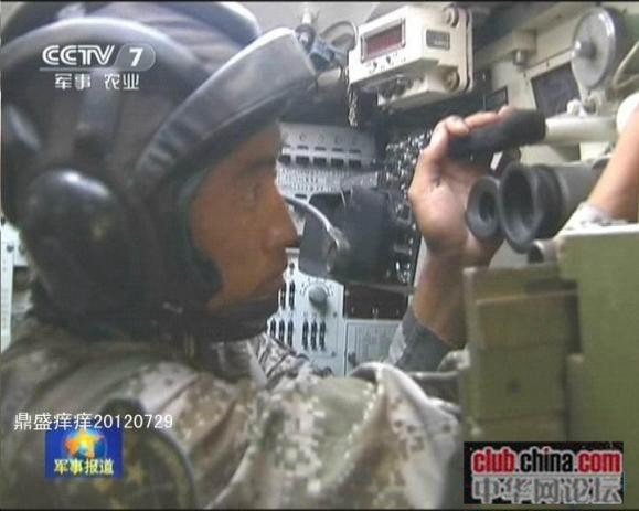  	Pháo thủ xe tăng Type 99 quan sát bên ngoài qua kính tiềm vọng. Kính ngắm này có thể quan sát mục tiêu bất kể ngày đêm. Ảnh: CCTV 7.