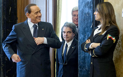 Cựu Thủ tướng Italia, Silvio Berlusconi cười với một nữ nhân viên khi trên đường tham dự một cuộc gặp gỡ báo chí.