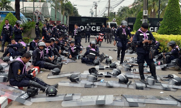 Một nhóm cảnh sát nghỉ ngơi trong khi đồng đội của họ vẫn theo dõi người biểu tình chống chính phủ tập trung trước CLB thể thao cảnh sát hoàng gia ở thủ đô Bangkok, Thái Lan.