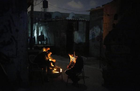 Những người Palestine tập trung quanh một đống lửa tại trại tị nạn Shati ở Dải Gaza.