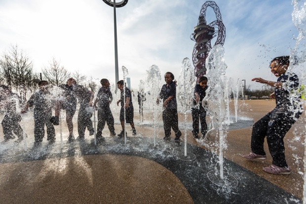 Trẻ em thích thú chơi trong đài phun nước tại công viên Nữ hoàng Elizabeth ở London, Anh.