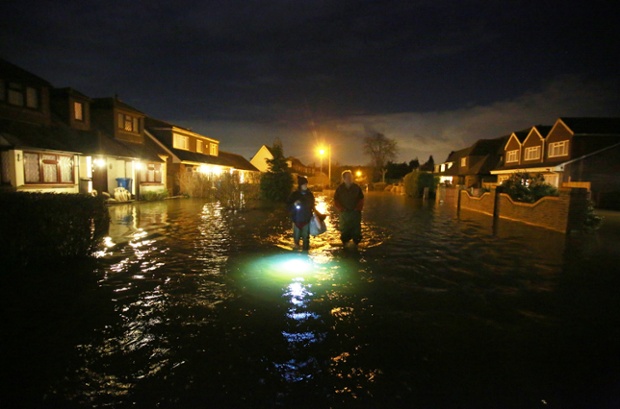 Mọi người đi bộ trong đêm qua đường phố ngập lụt ở Wraysbury, Berkshire, Anh.