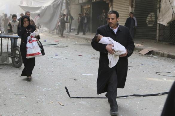 Người đàn ông bế một em bé sơ sinh khỏi hiện trường vụ không kích của quân đội chính phủ ở Aleppo, Syria.