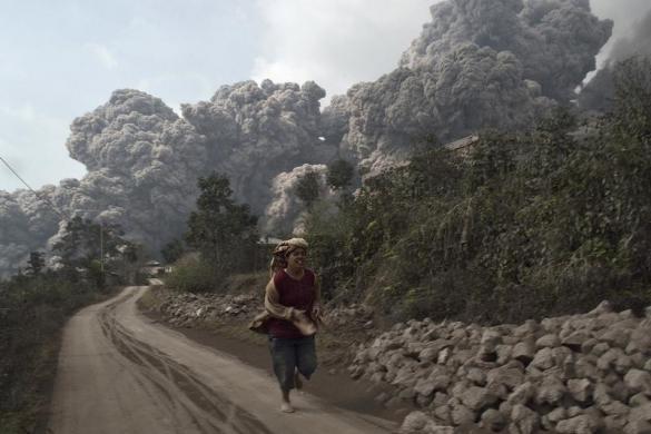 Một người dân bỏ chạy khi núi lửa Sinabung phun trào tro bụi gần ngôi làng Sigarang-Garang ở North Sumatra, Indonesia.