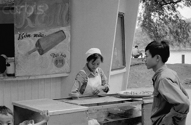 8. 24 Nov 1973, Hanoi, North Vietnam --- Hanoi: Hanoi Eskimo Pies. A woman vendor sells ice cream from a stand at the Lake of the Restored Sword in Hanoi. American antiwar activist Cora Weiss, who has recently returned from a visit to North Vietnam and Viet Cong held territories in South Vietnam, says the people there have a sense that they are building a new society out of the ruins of the war. --- Image by © Bettmann/CORBIS