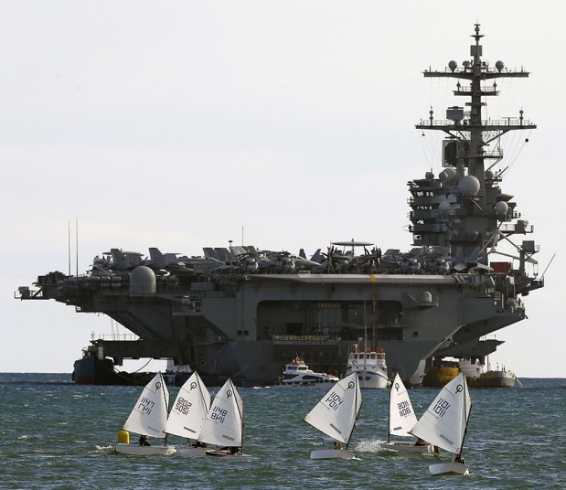 Mọi người lái thuyền buồm gần tàu sân bay hạt nhân USS George H.W. Bush của Mỹ ở cảng Piraeus gần Athens, Hi Lạp.