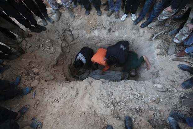 Các chiến binh phiên quân chôn cất thi thể một đồng đội thiệt mạng trong một vụ nổ ở Deir al-Zor, Syria.
