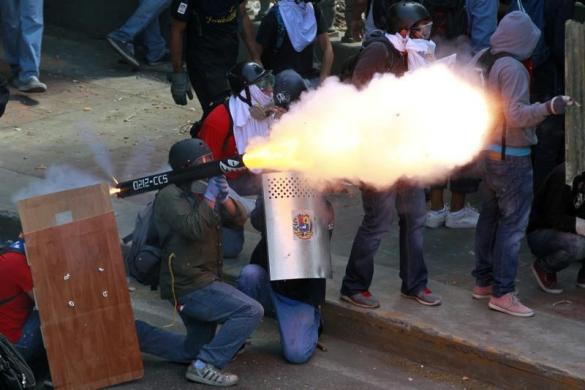 Một người biểu tình chống chính phủ phóng đạn cối tự chế về phía cảnh sát ở Caracas, Venezuela.