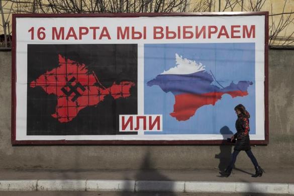 Một phụ nữ bộ qua tấm áp phích kêu gọi mọi người đi bỏ phiếu trong cuộc trưng cầu dân ý sắp tới ở Sevastopol, Crimea.