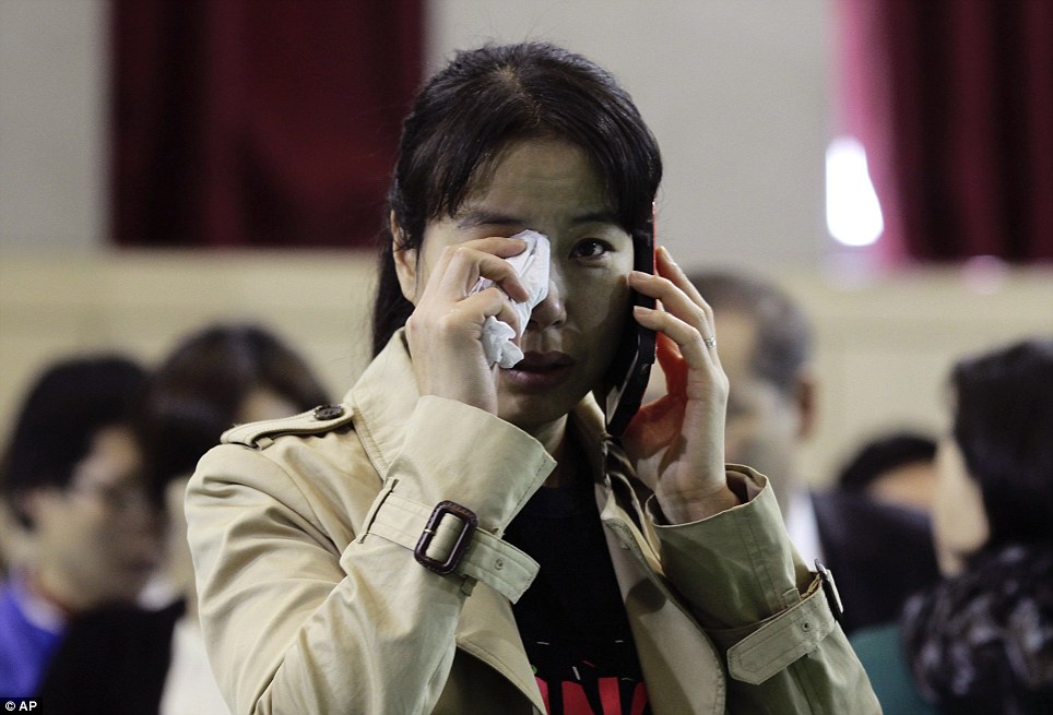 Quẫn trí: Một phụ nữ lau nước mắt khỏi mắt cô khi cô nói qua điện thoại tại Danwon High School
