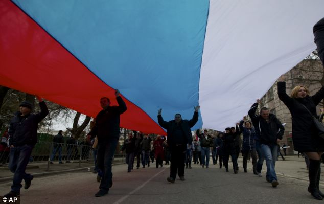 Người biểu tình Ukraine mang theo lá cờ Nga khổng lồ diễu hành trên phố
