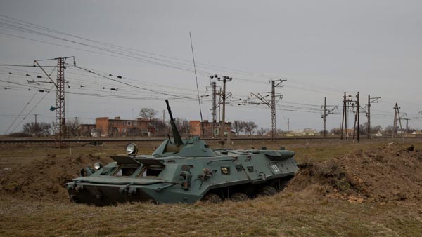 Một xe thiết giáp dòng BTR của quân đội Ukraine đang đậu ở dưới công sự trong tư thế sẳn sàng tiến lên.
