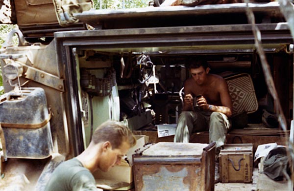 Hai lính thủy quân lục chiến Mỹ đang dùng khẩu phần ăn MCI bên trong một xe thiết giáp M113 tại chiến trường Việt Nam.