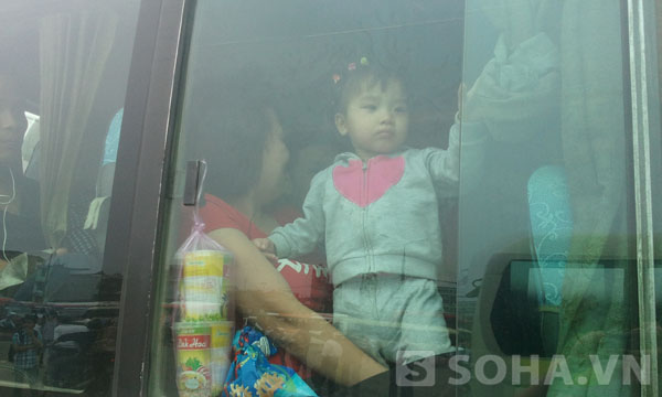 Một phụ nữ mang theo con nhỏ đã mua được ghế trên xe để về quê.