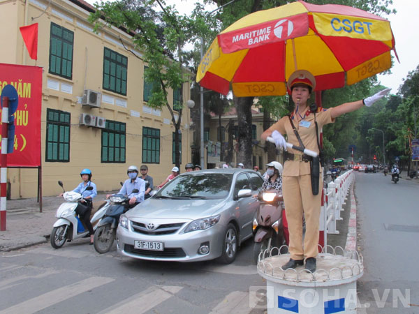 Một nữ cảnh sát thuộc Đội CSGT số 2 Công an TP Hà Nội đang điều hành giao thông tại ngã tư Nguyễn Thái Học – Tôn Đức Thắng.