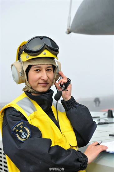 Nữ nhân viên trong trang phục vàng có nhiệm vụ hướng dẫn máy bay cất cánh, điều khiển bệ phóng và cáp hạ cánh.
