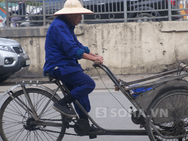 Cụ rất vui vẻ với công việc của mình, khi vừa đi vừa nhẩm tính đồng công,bên hông của cụ đeo một chiếc điện thoại rất to. (Đây là hình ảnh lúc cụ già vừa trả một chuyến hàng trên phố Trần Nhật Duật, Hà Nội)