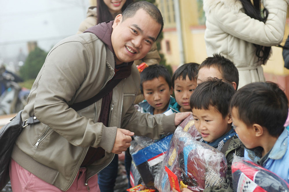 
	Nhạc sĩ Minh Khang trao quà tặng cho các em học sinh.
