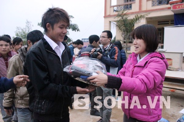 Chị Nguyễn Thị Huyền Thanh trao chiếc áo ấm cho các em học sinh.