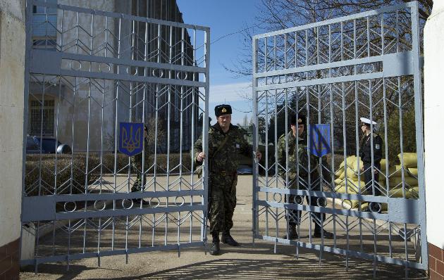 Một binh sĩ Ukraine đóng cánh cổng trụ sở căn cứ hải quân ở Novoozerne (Crimea)