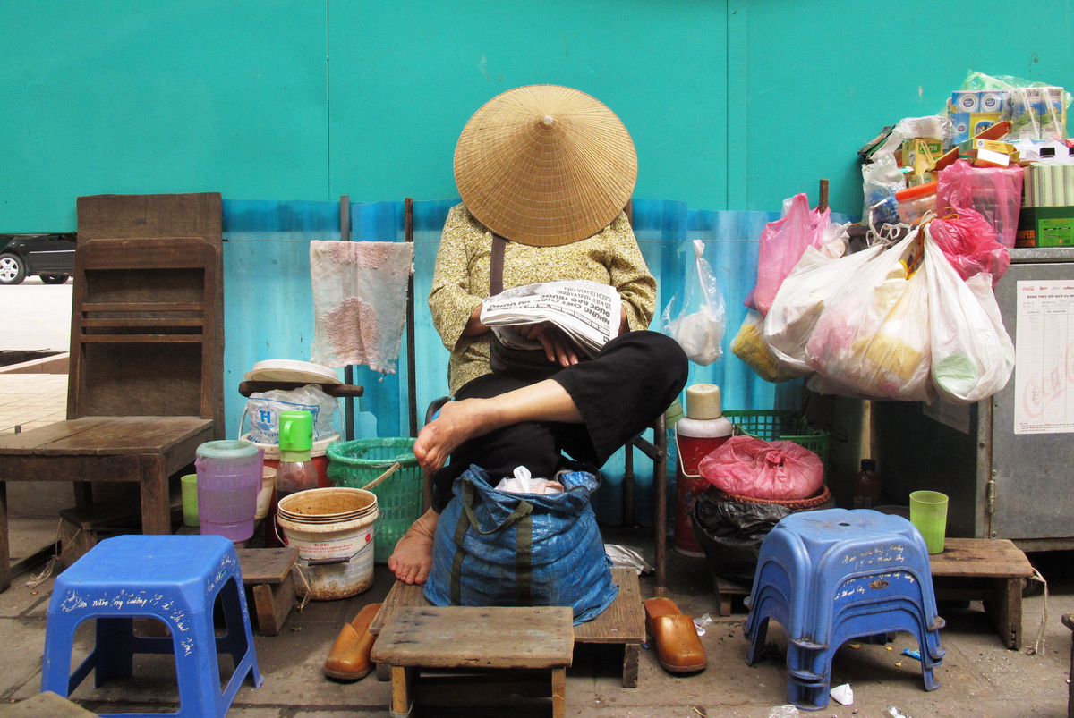 Giấc ngủ trưa vội vã dưới nón của một cô hàng nước ở Hà Nội, Việt Nam. Ảnh chụp 21/12/2012. (Chris Brummitt / AP)