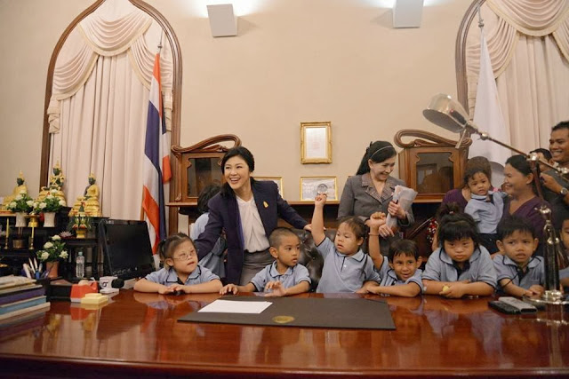 Bà Yinguck vui vẻ bên những đứa trẻ tại bàn làm việc của mình.