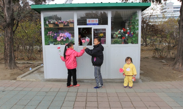  	Ba em bé đang mua hoa tại một cửa hàng hoa ở Bình Nhưỡng nhân Ngày của Mẹ.