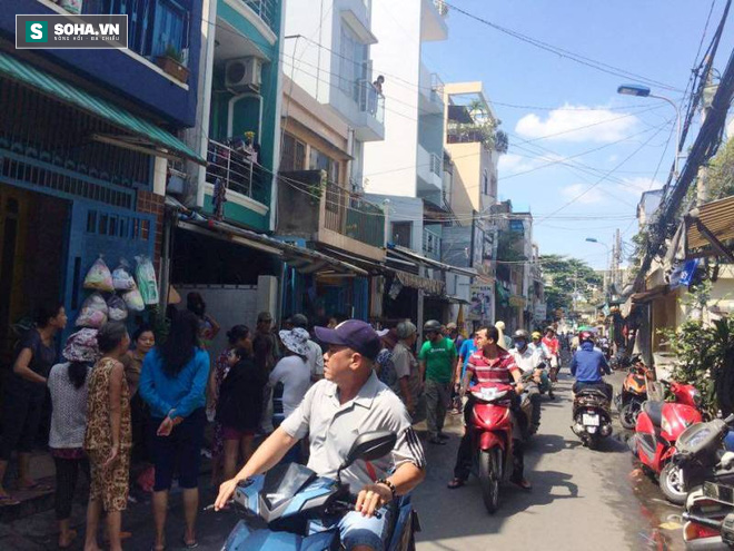 Bé gái cùng người thân thẫn thờ bên ngôi nhà bị thiêu rụi hết tài sản - Ảnh 1.