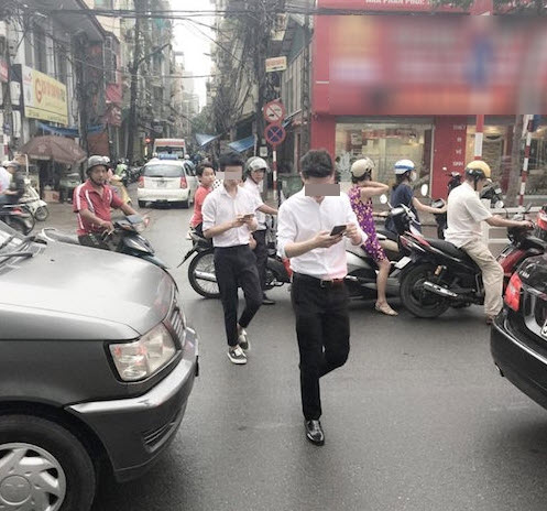 2 hot boy bất chấp nguy hiểm bắt Pokemon giữa đường Hà Nội - Ảnh 1.