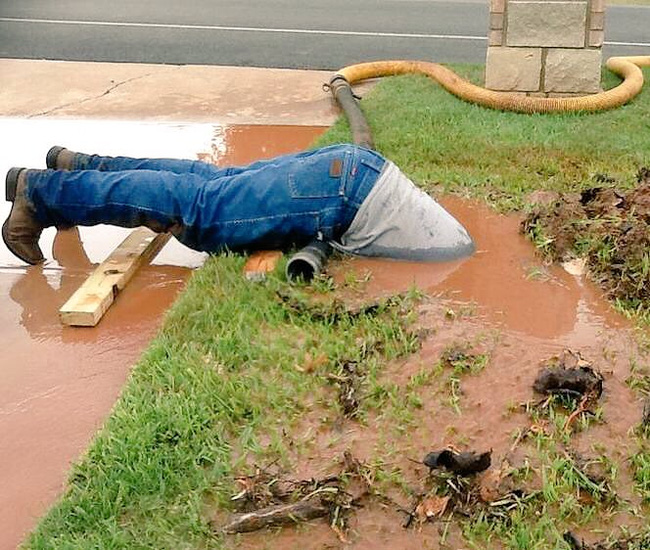 Bức ảnh nhân viên Mỹ vục mặt trong bùn sửa đường ống nước gây bão mạng xã hội - Ảnh 1.