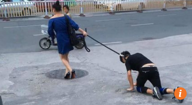 Trung Quốc: Người phụ nữ gây tắc đường vì xích cổ, dắt nam thanh niên đi dạo - Ảnh 1.