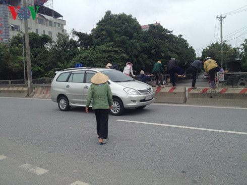 Dân xếp gạch đá chặn đường đi Nội Bài vì không có cầu vượt - Ảnh 1.