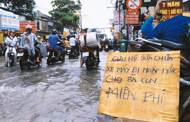 Câu chuyện đẹp về 3 anh em sửa xe miễn phí cho bà con mùa nước ngập Sài Gòn vào đề thi - Ảnh 1.