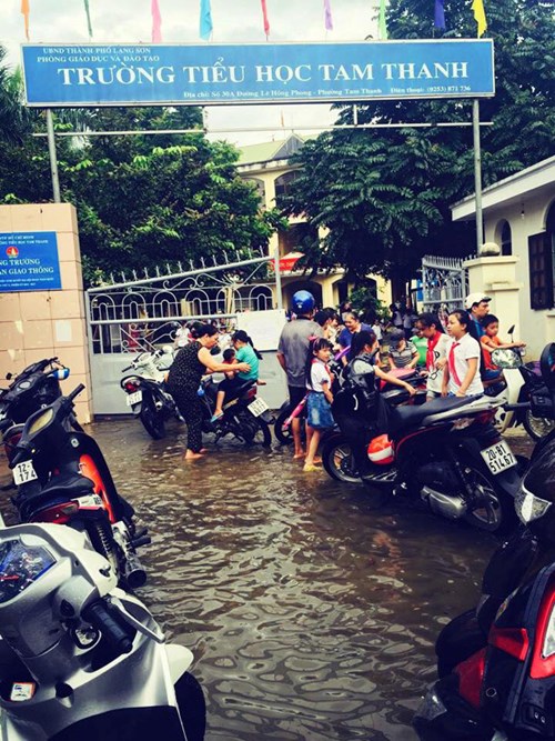 Mưa lớn quây trường học, phụ huynh hốt hoảng lội nước tìm con - Ảnh 1.