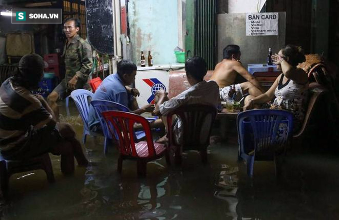 Người Sài Gòn đeo ủng ngồi giữa nhà ngập nước đọc báo, xem tivi - Ảnh 1.