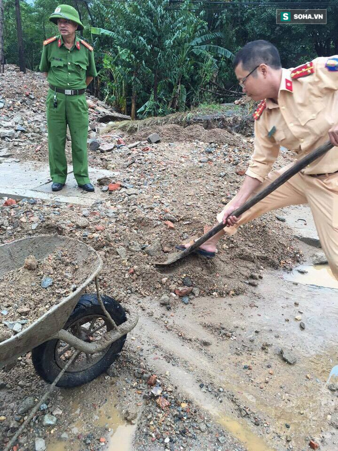 Hà Tĩnh: Công an xắn quần, đội mưa dọn đất đá vương vãi trên đường - Ảnh 2.