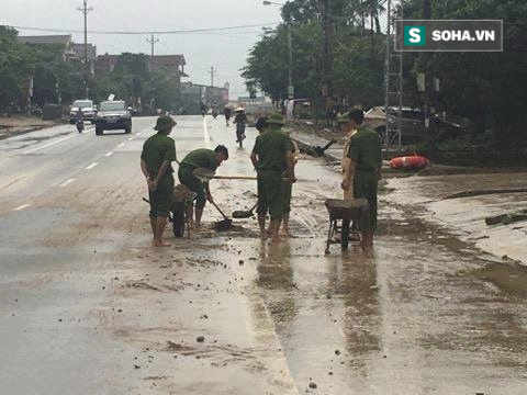 Hà Tĩnh: Công an xắn quần, đội mưa dọn đất đá vương vãi trên đường - Ảnh 3.