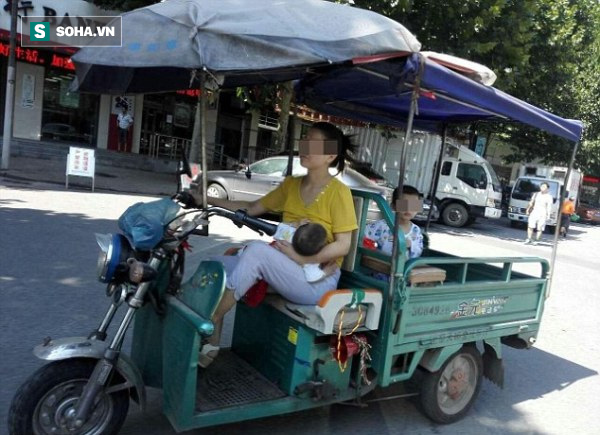 Bà mẹ trẻ nổi tiếng vì vừa lái xe ba gác, vừa cho con nhỏ bú ngay giữa đường phố - Ảnh 1.