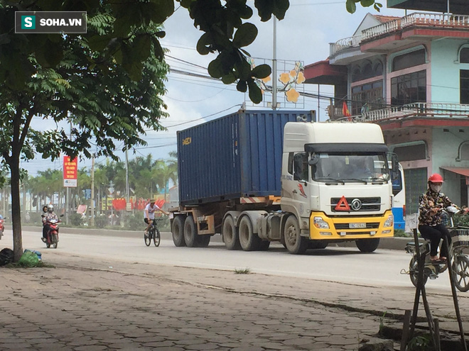 Hoảng hồn chứng kiến nam thanh niên bám đuôi container đang chạy - Ảnh 1.