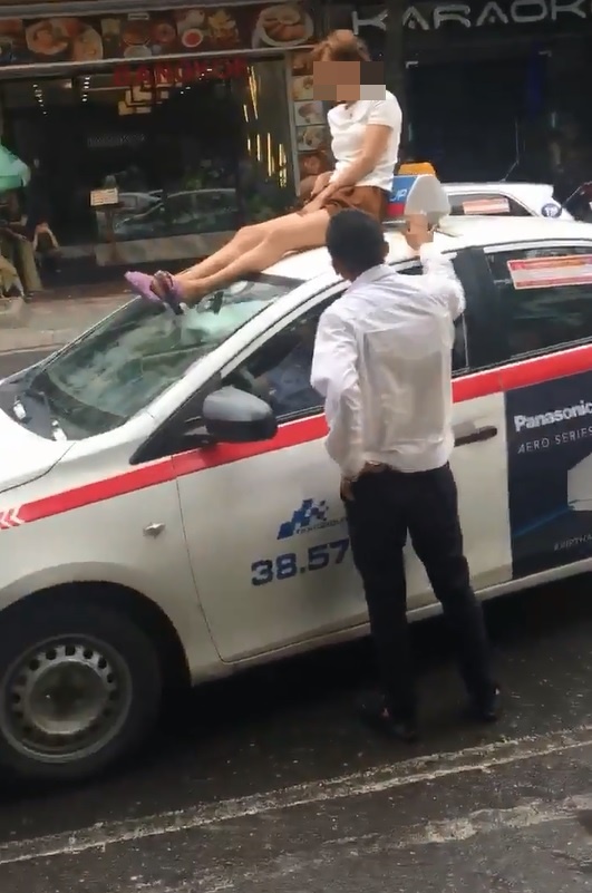 Người phụ nữ trèo lên nóc xe taxi “ăn vạ” giữa phố Hà Nội  - Ảnh 1.