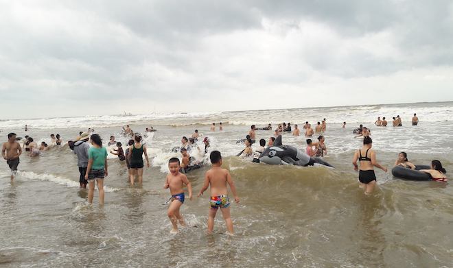 [Ảnh] Mặc bão vào, hàng trăm du khách liều mình tắm biển rồi bỏ chạy khi có sóng lớn - Ảnh 9.